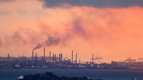 日落时从工业区冒出的黑烟污染剪影