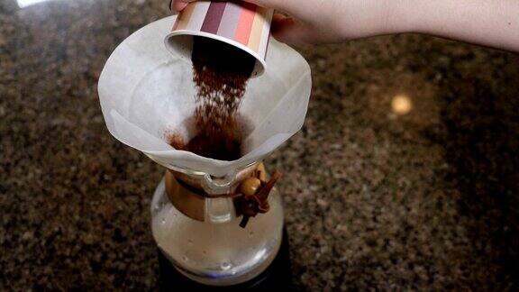 现代和另类的咖啡制作方法一个咖啡师制作手煮咖啡的特写加入磨碎的咖啡倒入热水慢动作