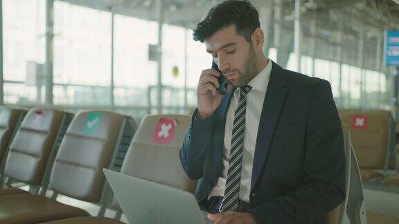 商务人员在机场使用笔记本电脑和手机
