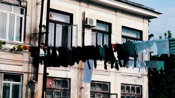 大量洗好的衣物挂在绳子上晾干在房子附近的街道上