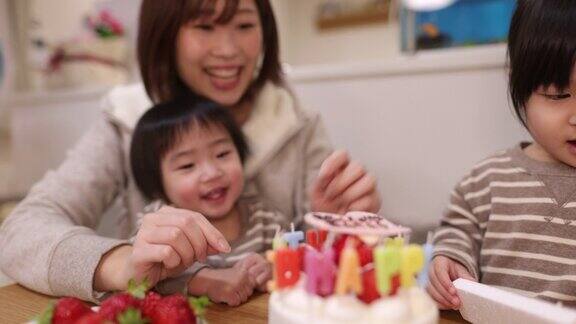 一个年轻的家庭为儿子的一岁生日在蛋糕上放蜡烛-2的一部分