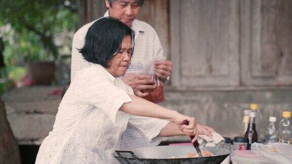 亚洲人的祖父和祖母在家里烹饪传统食物