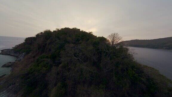鸟瞰图电影热带岛屿山郁郁葱葱的绿色岩石海岸泻湖海水日落