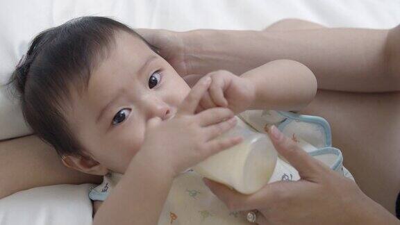 母亲用奶瓶喂亚洲新生女婴
