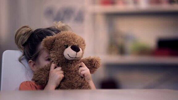 悲伤的女孩子被泰迪熊玩具蒙着脸家庭问题孤独虐待