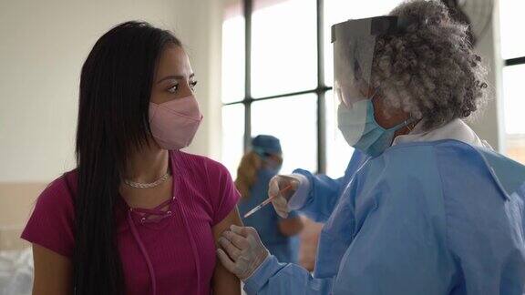 年轻妇女正在接种疫苗-戴口罩