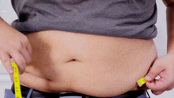 超重男子用卷尺检查自己超重健康真实的身体