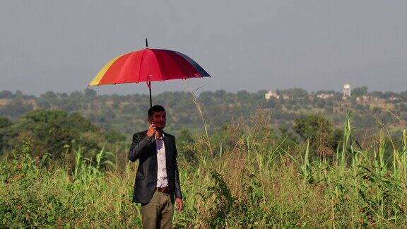 商务人士拿着五颜六色的雨伞在户外大自然中