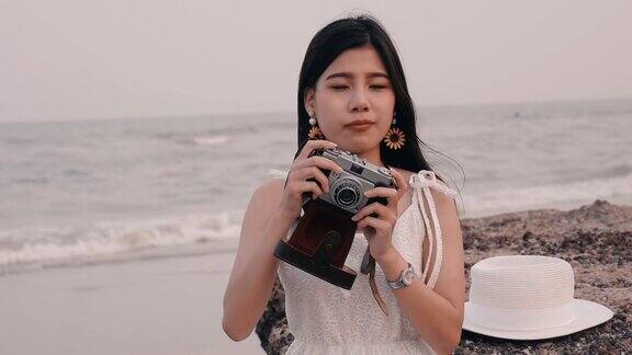 拿着老式相机的女孩海滩