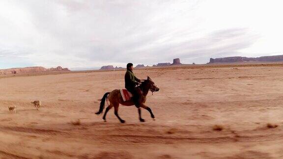 一个纳瓦霍男孩在纪念碑谷骑马的移动镜头