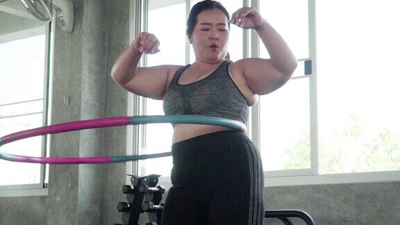 超重的年轻女子在练习呼啦圈