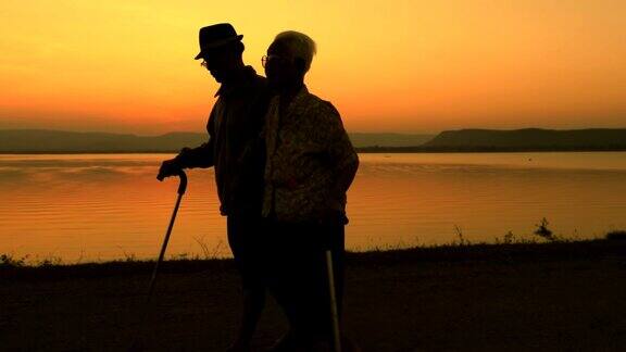 老年亚洲夫妇在湖边散步概念健康和相爱慢镜头