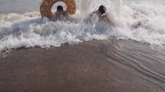 三个孩子在享受海滩大海和海浪