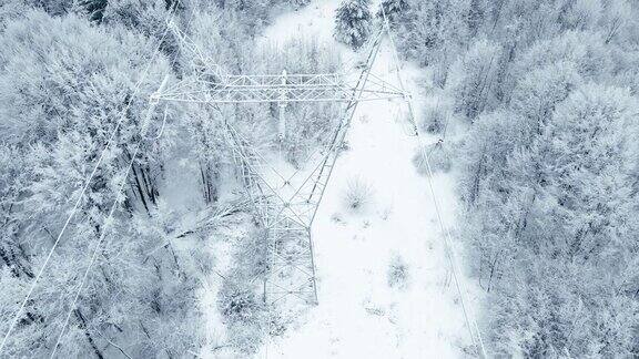 冬季高空鸟瞰图高压线在雪山森林