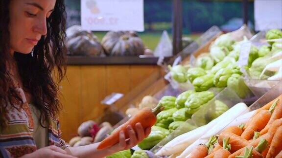 年轻漂亮的女孩或女人在市场上买食物在超市里买胡萝卜