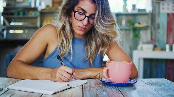 年轻女子在咖啡馆写作