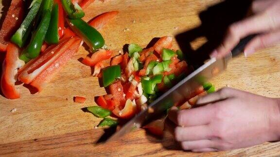 将青椒和红椒放在切菜板上亲手切丁