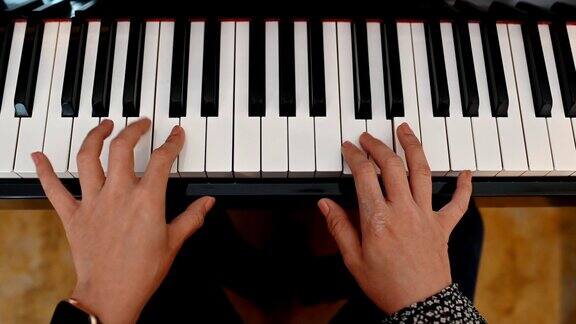 手握女性练习弹奏钢琴