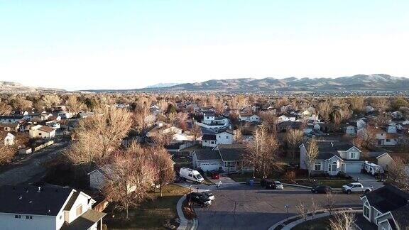 在一个晴朗、阳光明媚的日子里背景是山脉无人机拍摄的郊区单户住宅社区