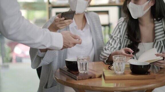 Hand的顾客在咖啡店使用手机进行电子支付