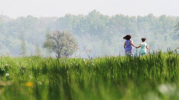 母亲和女儿在春天的田野上奔跑
