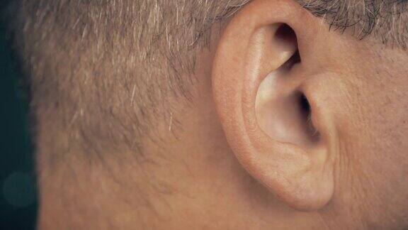 一个成年人在听音乐人的右耳宏观极端近距离观察男性耳朵概念音响音乐健全健康人耳