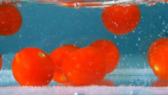 西红柿落在蓝色的淡水里高速摄像机拍摄