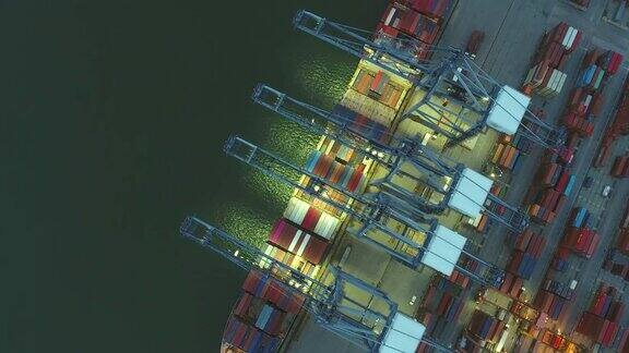 工业港口集装箱船工作起重机夜间俯视图航拍视频