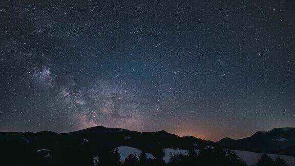 繁星点点的夜晚时间流逝银河星系天文星星移动过山林黑夜到白天