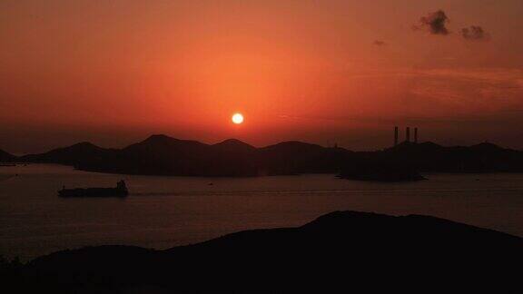 美丽的日落在南丫岛发电厂在香港-一艘货船经过