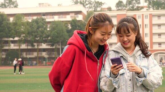 两个快乐的亚洲女孩在校园里聊天