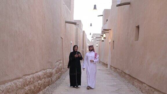 一对中年沙特夫妇在图拉伊夫遗址中漫步