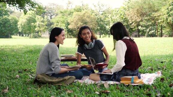 三个多元化的大学生朋友在公园里笑着