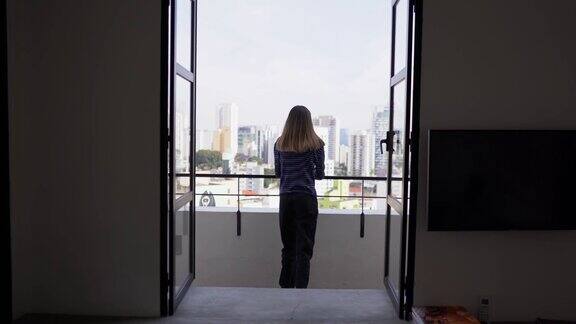年轻女子在公寓的阳台上沉思