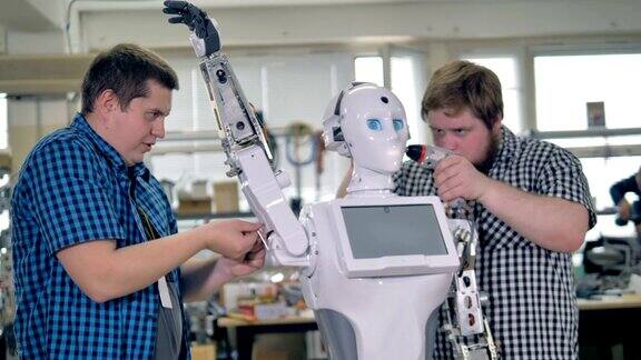 车间工人组装机器人的手臂和头部
