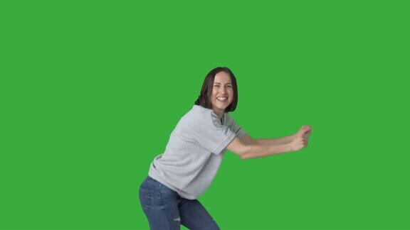 兴奋的女人在绿色的背景上跳舞