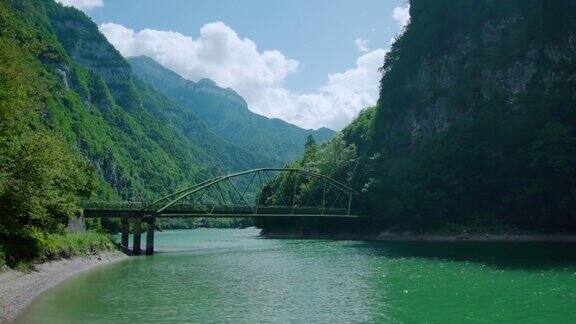 一座现代金属桥横跨山间的河流