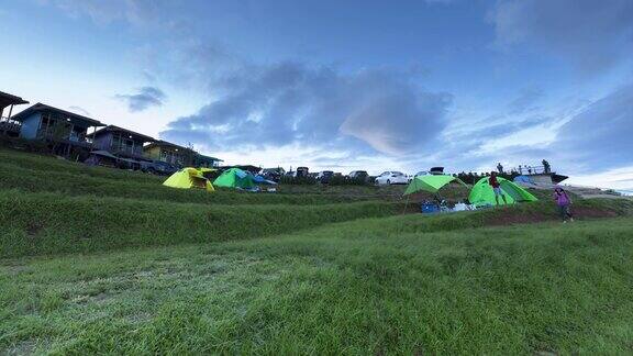 晴朗的天空下绿色的草地上搭着露营帐篷