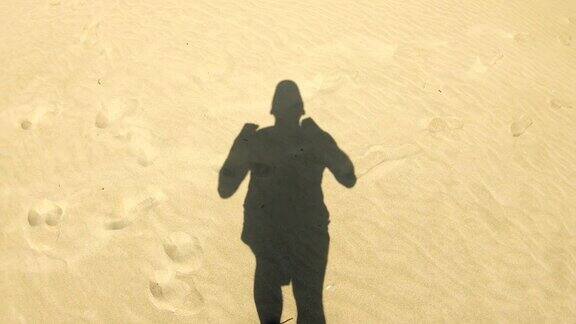 在海滩上慢跑的人移动的影子