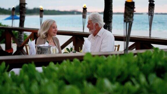 一对退休白人夫妇在海滩酒店吃饭