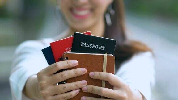 亚洲女人微笑着拿着护照和机票