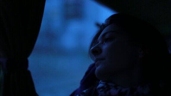 晚上一个女孩望着窗外黄昏时分一名女子在公交车上向窗外望去