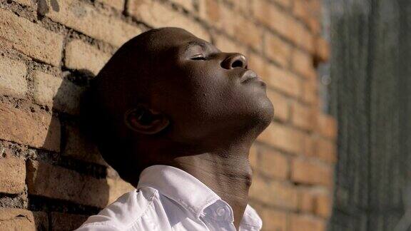绝望孤独的黑人青年抬头望着绝望在户外祈祷
