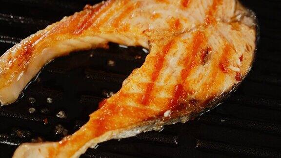 新鲜的鲑鱼排在煎锅里用油煎