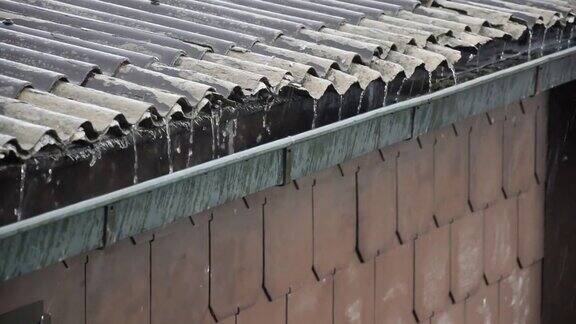 城市里的大雨从建筑物上倾泻到街道上和屋顶上雨水从屋顶上滴落下来