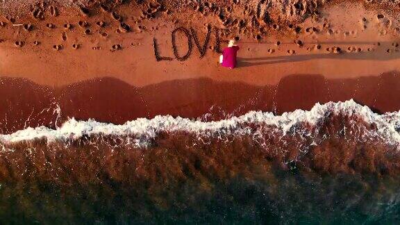 女孩把爱写在沙滩上