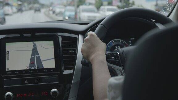 女子驾驶一辆带有地图显示的汽车在城市道路上导航