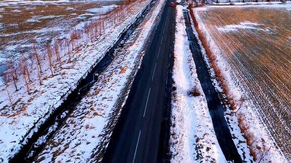 鸟瞰被白雪包围的道路一辆白色汽车在夕阳下-冰岛