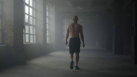 一个人的剪影走在黑暗的走廊里运动员锻炼后休息