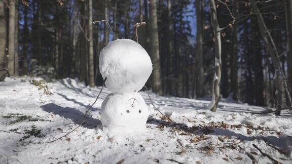 在一个阳光明媚的冬日里雪人倒立在森林里